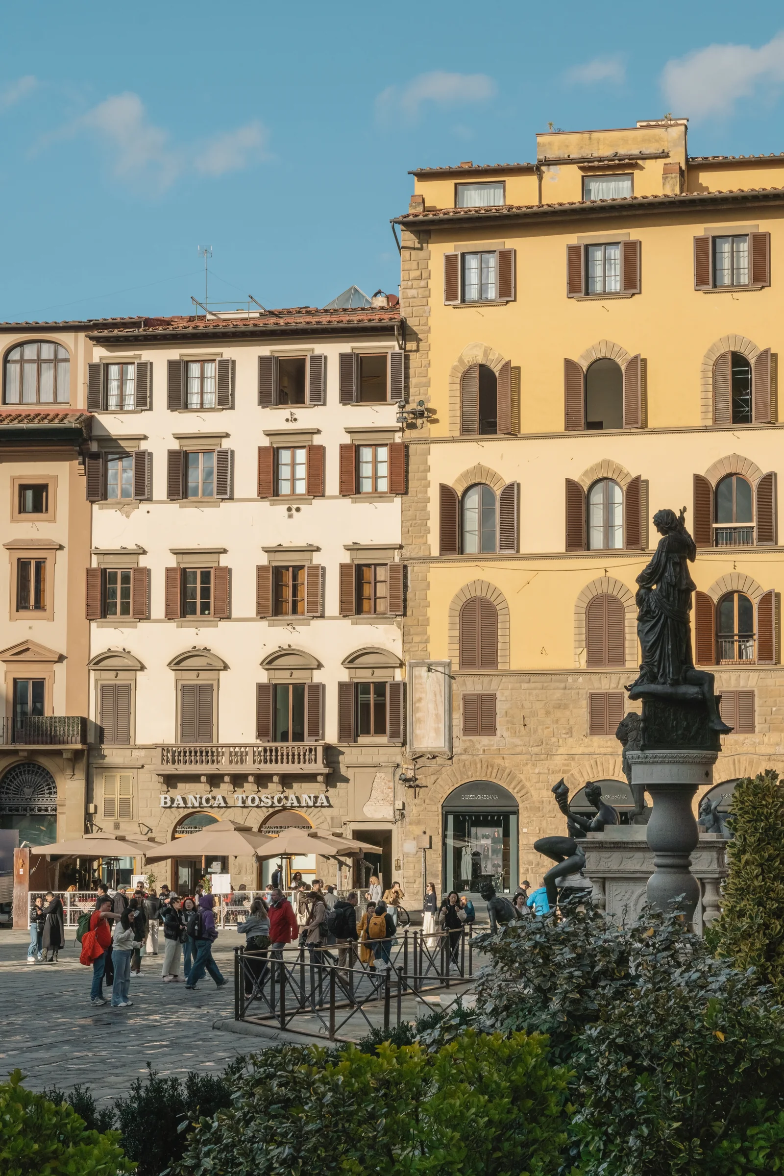 Piazza della Signoria with the Fountain of Neptune and shuttered facades under blue sky