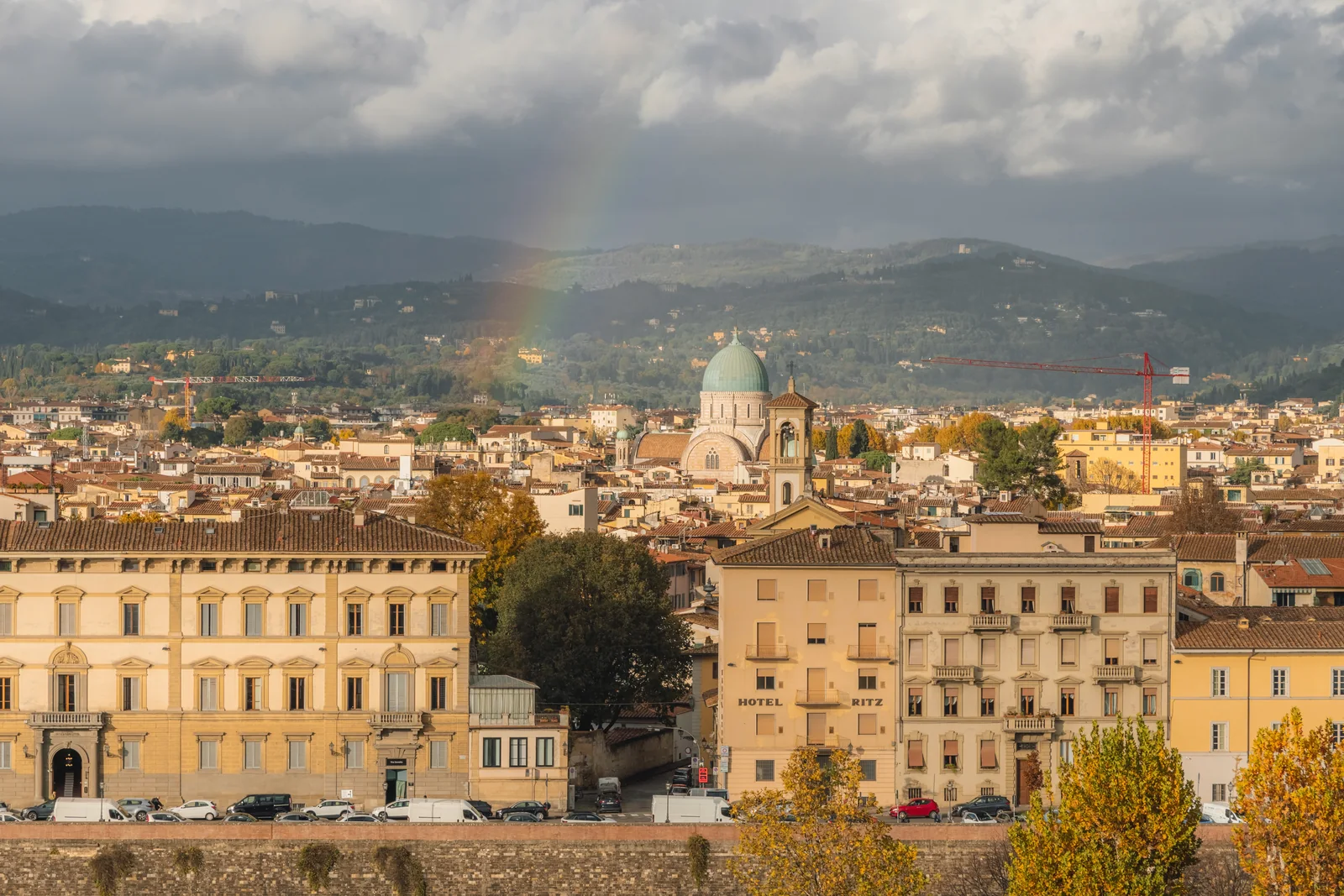 Faint rainbow over Florence rooftops, the green dome of the synagogue and Hotel Ritz below