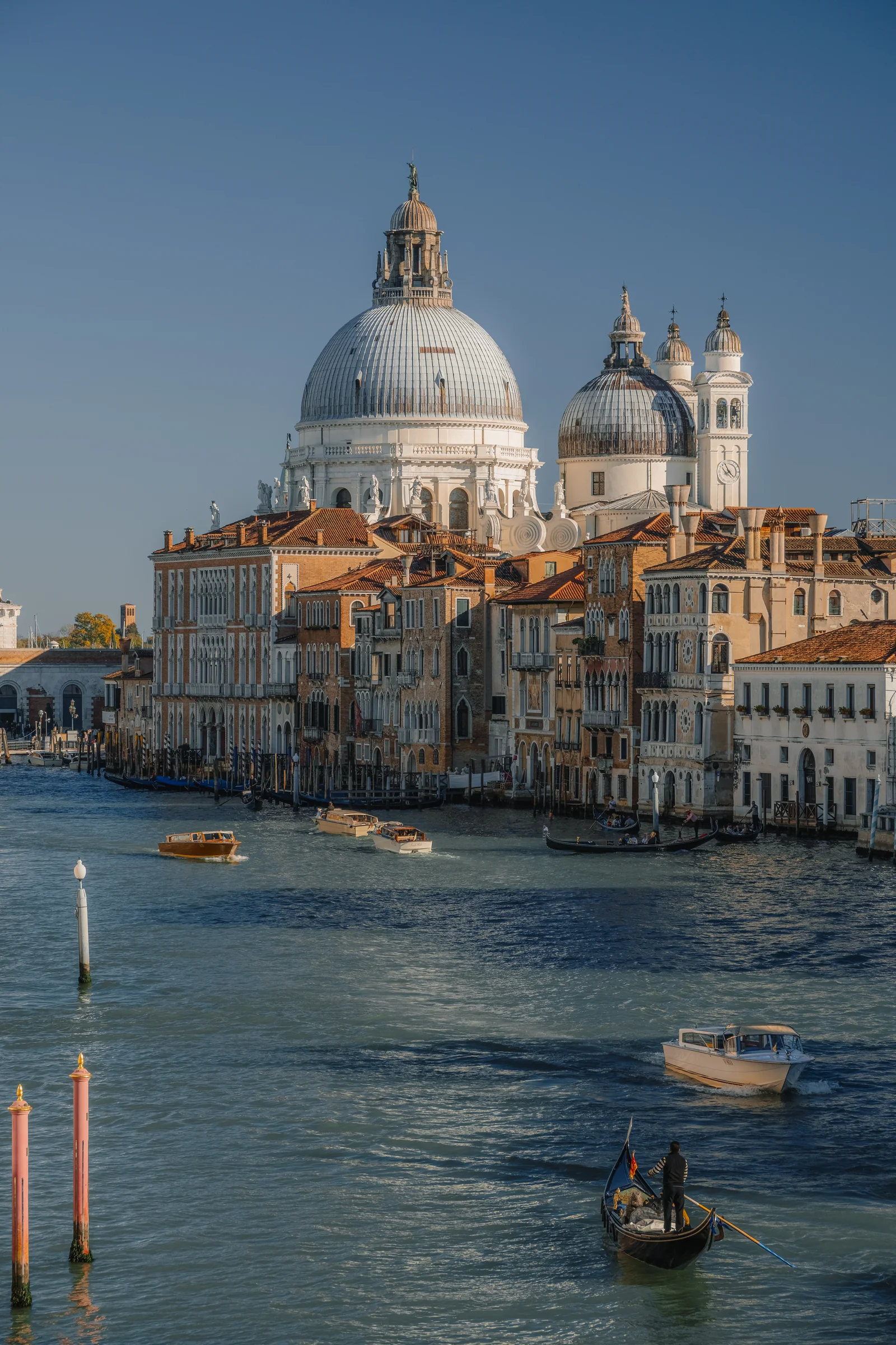 The domes of Santa Maria della Salute above the Grand Canal, water taxis and a gondola below